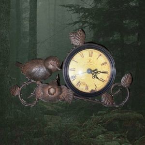 antique metal analog clock with bird